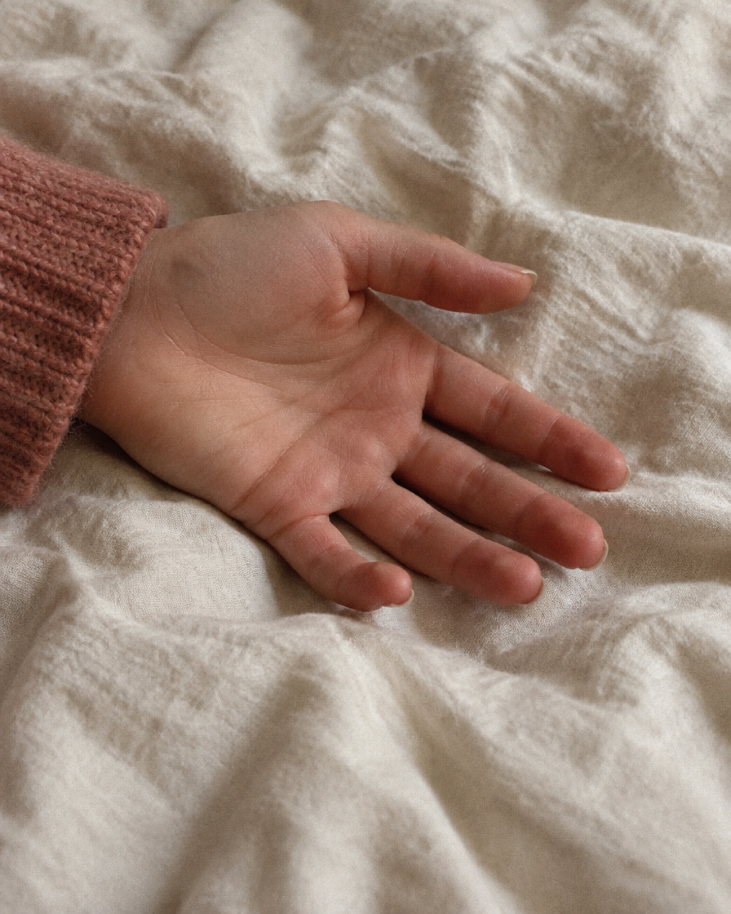Main ouverte posée sur un drap de lin froissé